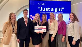 Uzvarējusī komanda "Just a girl" kopā ar Latvijas Bankas pārstāvjiem, turot rokās diplomu